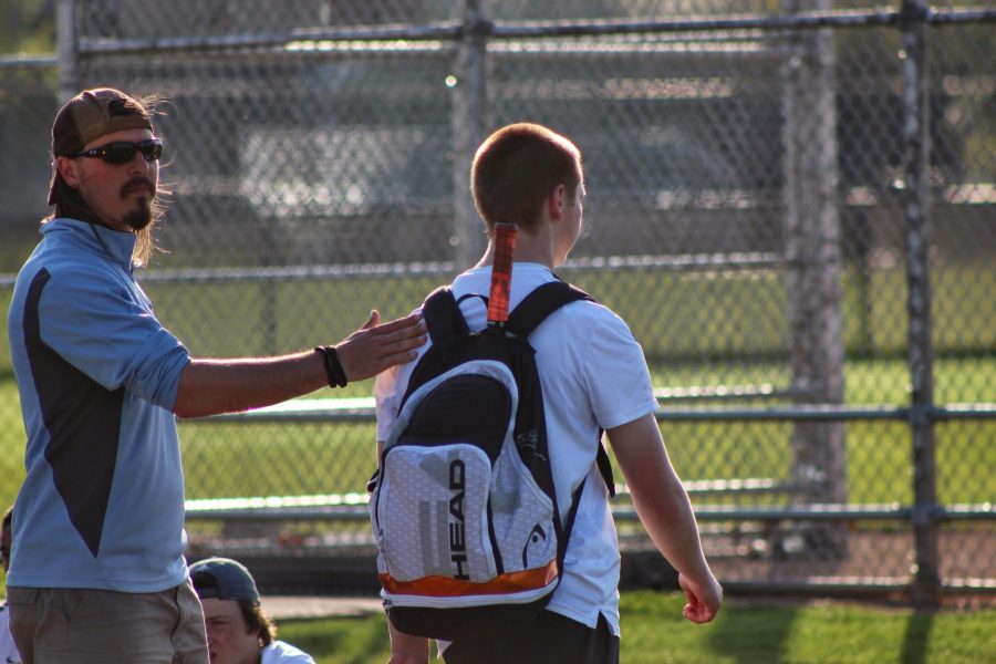 GOOD WORK: Head varsity coach Tom Kujawa pats junior doubles player David Slupski on the back after a hard fought match at Hersey on May 7.