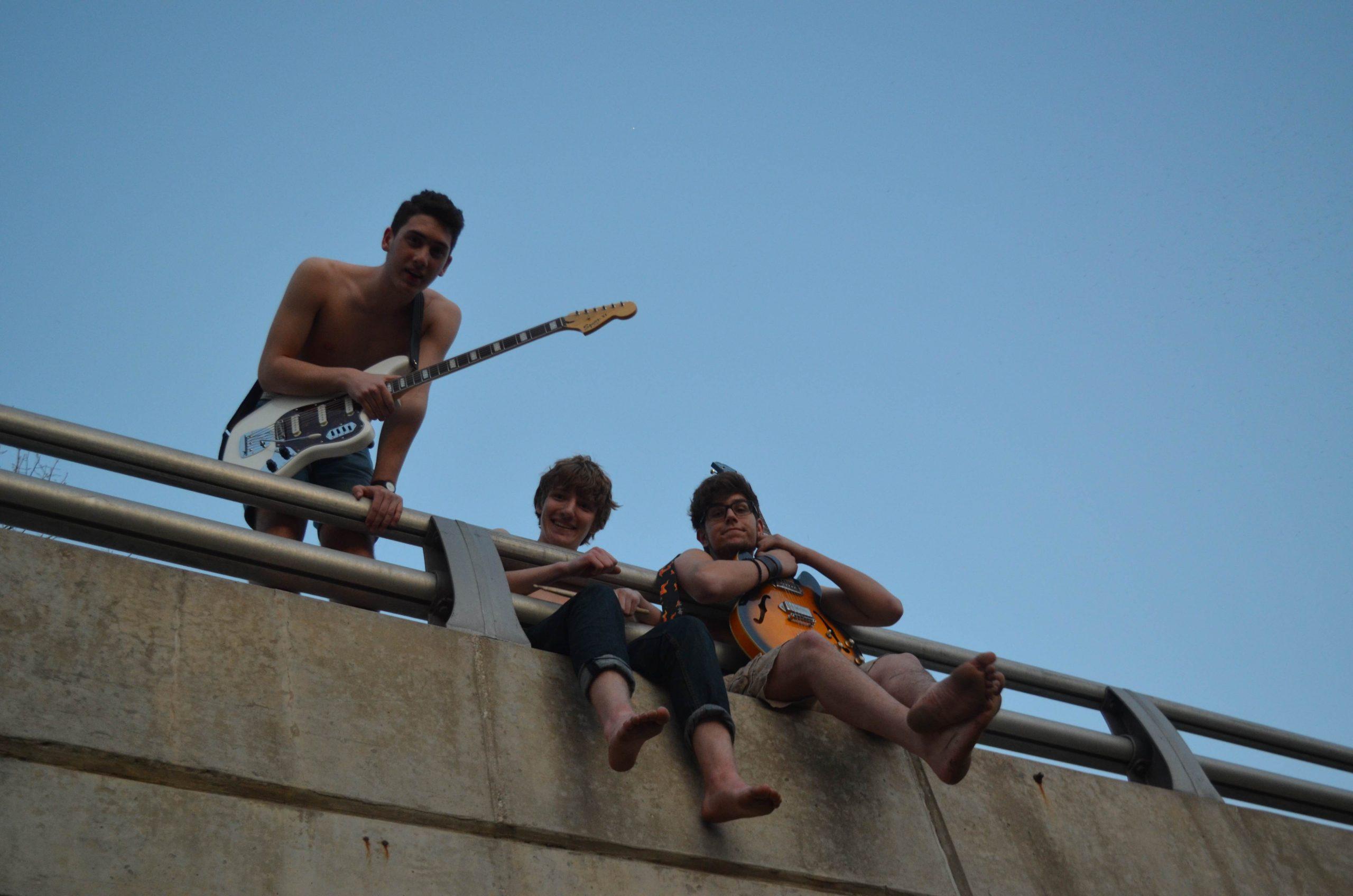 Junior Dylan Cessna poses with his two band mates. The band, Fairbank Italics, is one of several bands performing at the Band-aid benefit concert.
