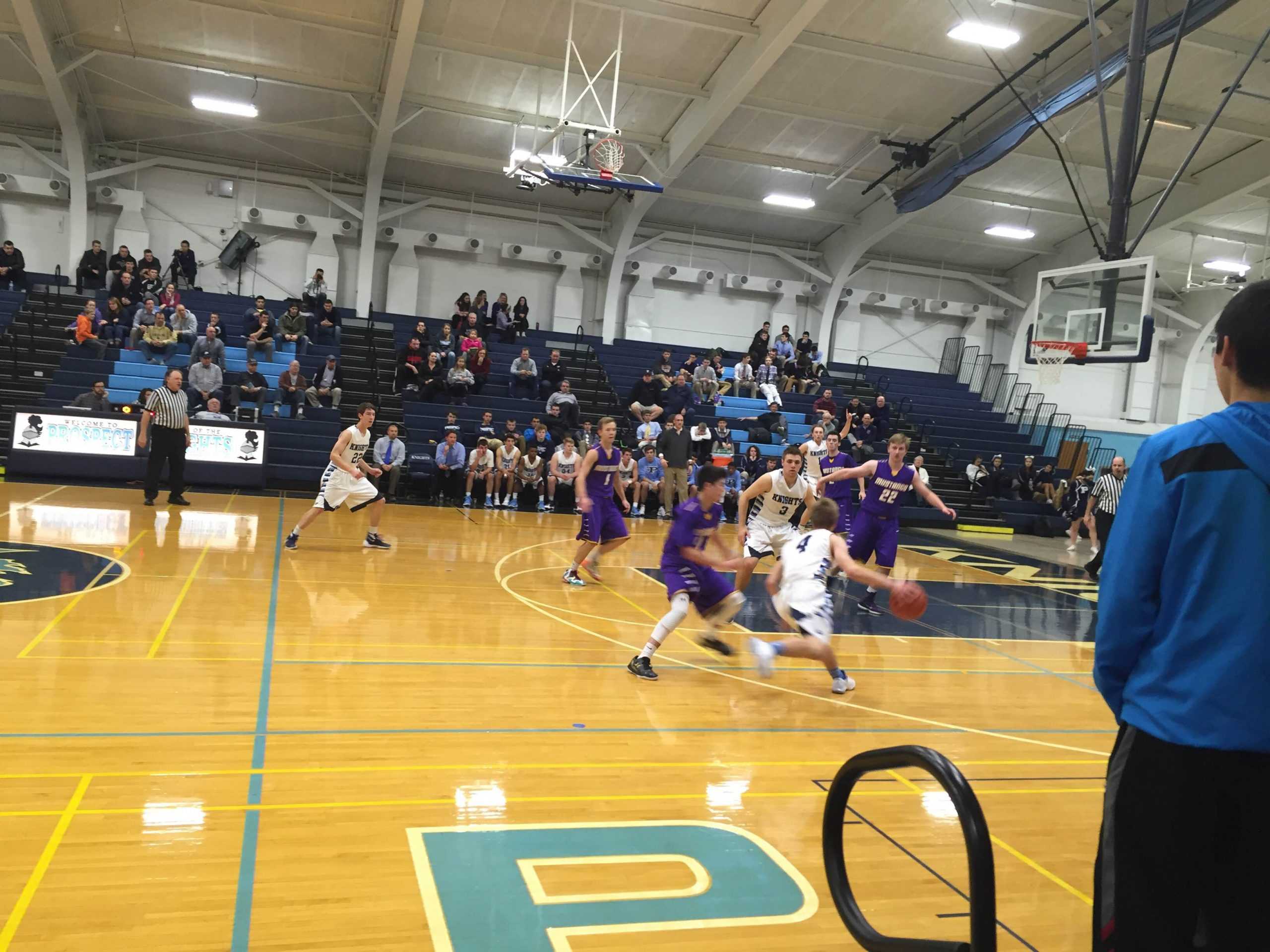 RISING STAR: Sophomore David Swedura drives the lane against Rolling Meadows in their game on Dec. 10. Swedura contributed to the Knights 30-29 win with 3 points, 3 assists, and 3 rebounds. (Photo by Jack Ankony)