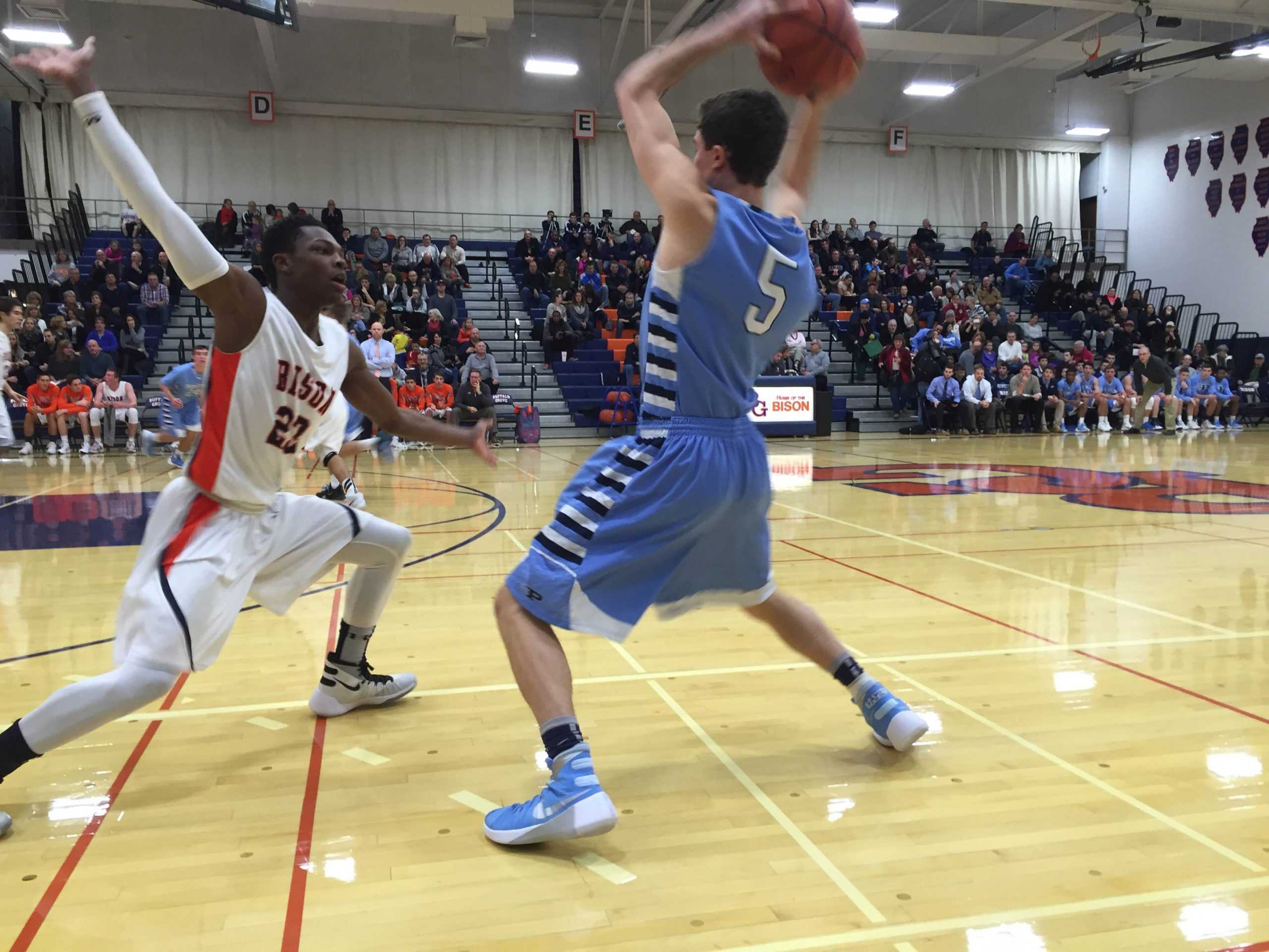 Swingman: Senior Liam Benson scans the defense looking for an open teammate vs. Buffalo Grove on Jan. 16. Benson contributed with two points, one assist and one rebound. In this game Benson made both of his two attempted free throws.