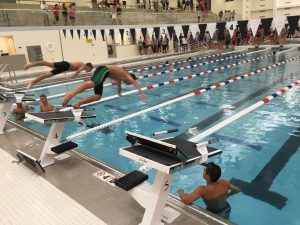 Two swimmers take their inaugural starts off the blocks in the new swimming pool. The pool is 40 meters long, so swimming and diving events can take place concurrently, unlike at the team's former pool at Wheeling.