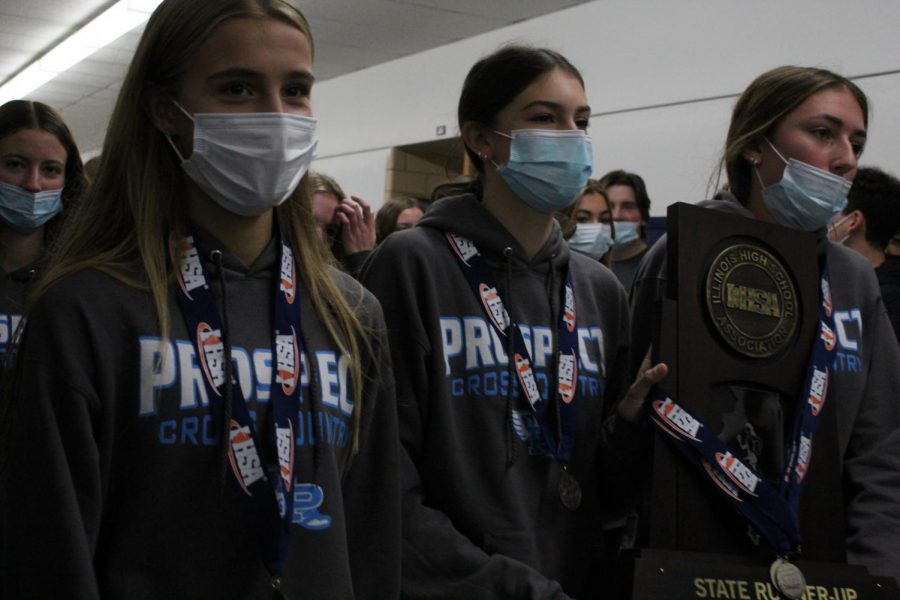 Top runners, junior Hailey Erickson, senior Audrey Ginsberg, and junior Cameron Kalaway lead the entire team through the halls. The girls showcase their new hardware, a state runner-up trophy along with IHSA medals, to the entire student body lining the halls.