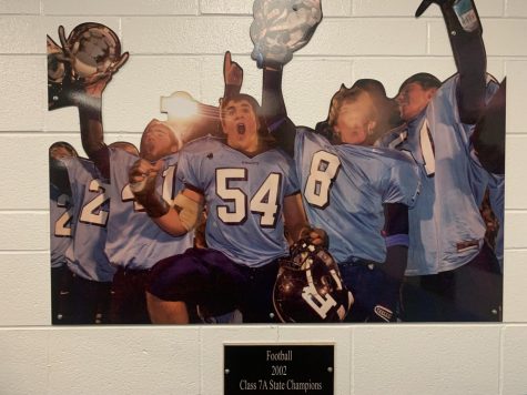 The photo from the 2002 state championship team hangs proudly in the weight room. Before heading to the state championship, the Knights took down the Buffalo Grove Bison in the quarterfinals by a score of 17-16.