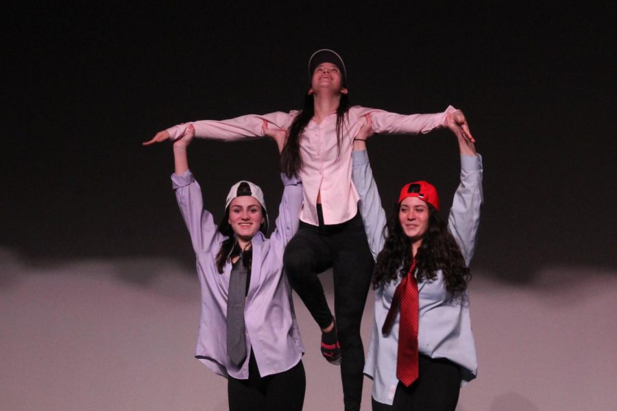 Anna Parisi and Emily Naveja lift up Kelly Jordan during their performance. 