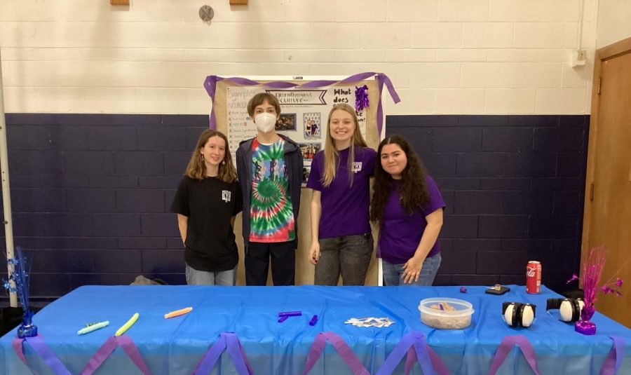 Junior Ava Foster, Senior Harry Zalusky, Junior Cate Marchialette and Sophomore Maya Weir pose in front of their booth at Prospects Multicultural fair. (Photo by Tessa Trylovich)