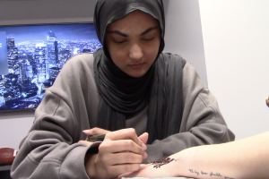 Senior Maliha Waheed designs henna on a client. According to Waheed, it is important to think quickly in order to make creative designs and make the client happy. (Photo by Emma Letzig)