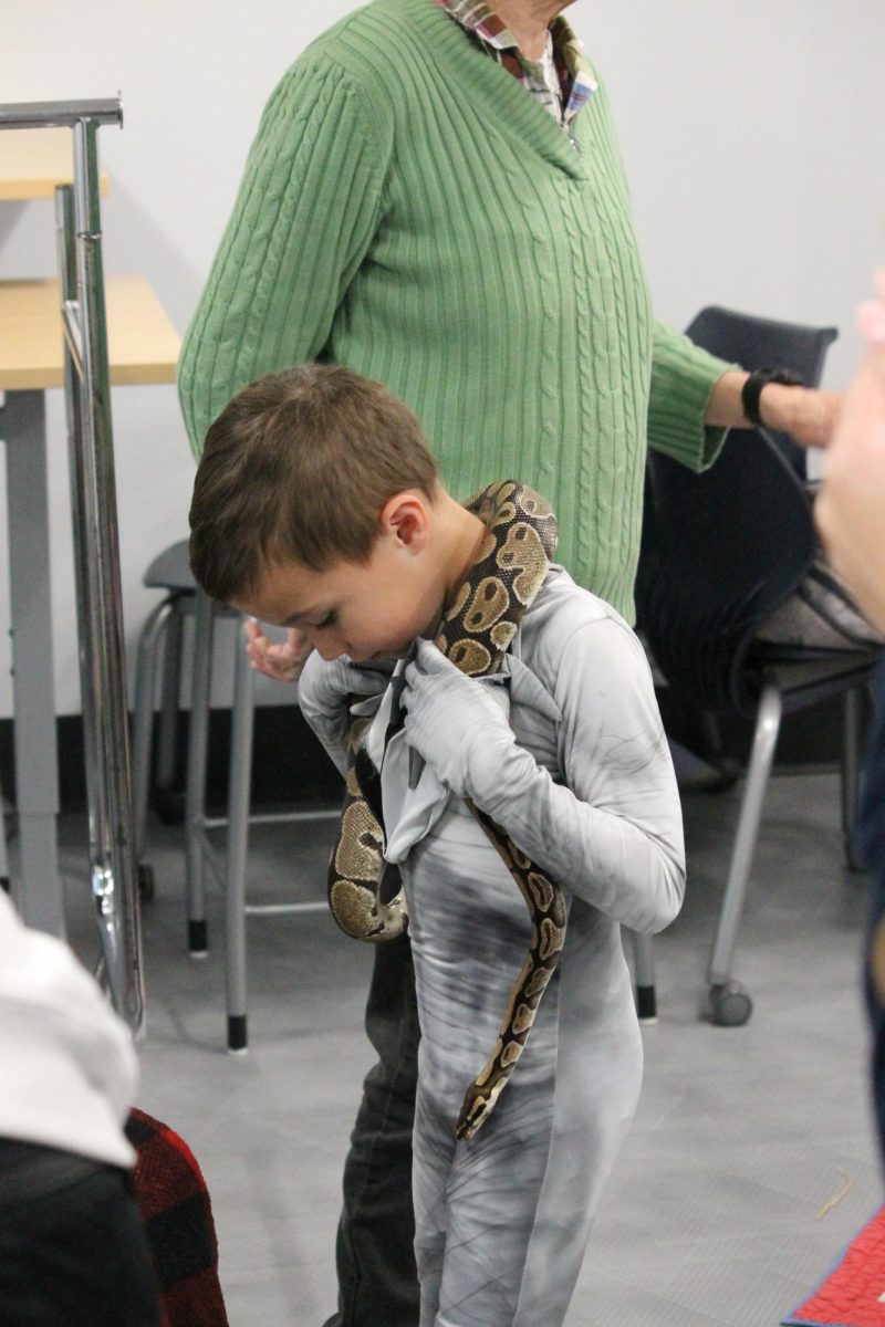 Young boy with a snake on his neck at Haunted High School.