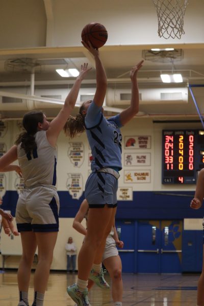 Sophomore Ali Linke laying up the ball into the hoop.