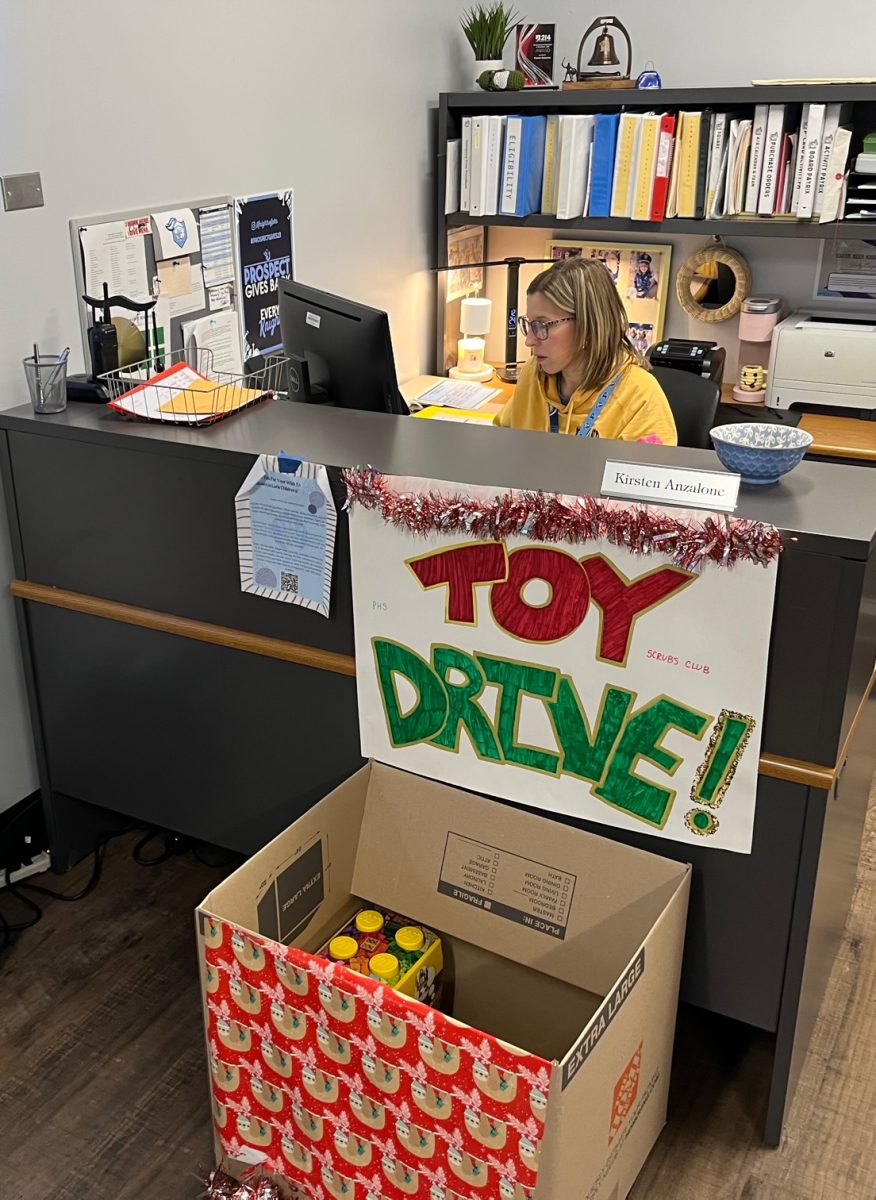 Bookkeeper and Student Activities staff member Kirsten Anzalone works at her desk in the Student Activities office. A toy drive collection bin to further encourage both students and staff to donate.