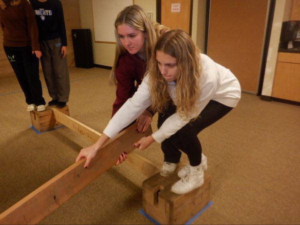 Caption: Senior Via Reed and junior Mia Kaddatz work together in order to set up an obstacle course to help team building. (photo courtesy of Tori Kurchiy)