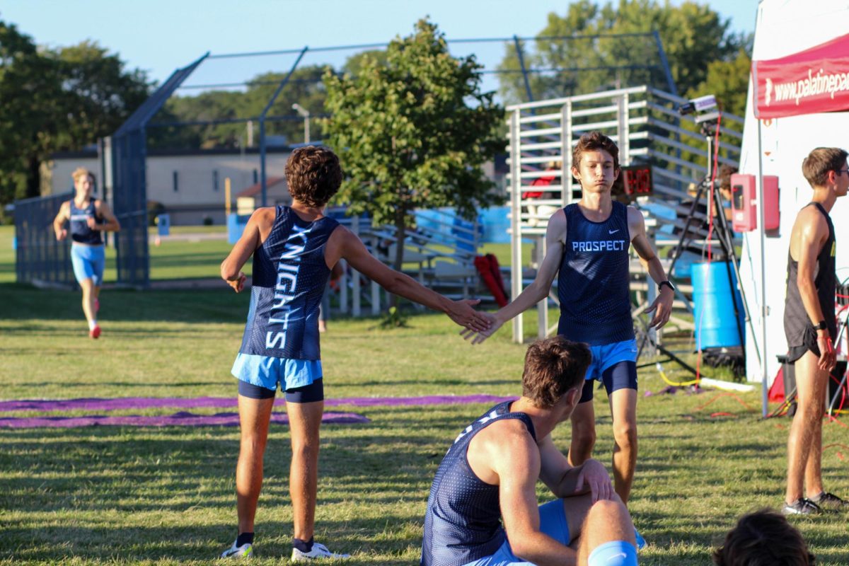 Junior Brody Cushing and junior Liam Wineberg exchange a high five after the 3 mile race. 