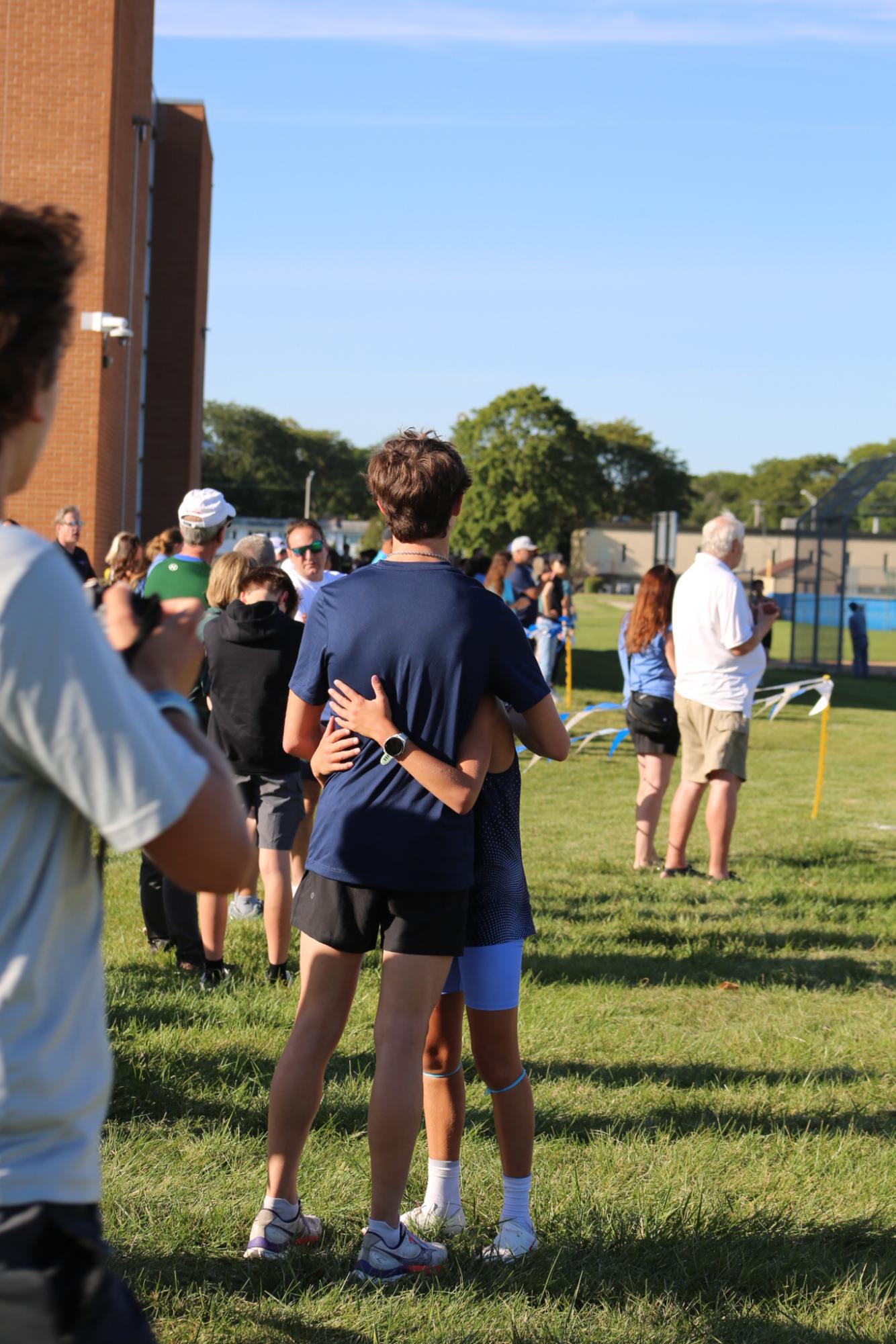 Sophomore Landon Samp embraces freshman Nate Favia after finishing his first race of the season. 