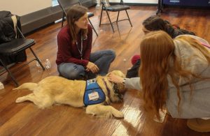 Students petting Gethsemane, a comfort dog in training. 