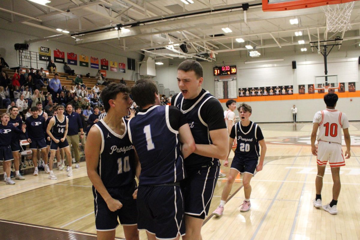 Junior Will Stratigos (Left) and sophomore Dany Simon (right), celebrate senior Ben Schneider’s layup