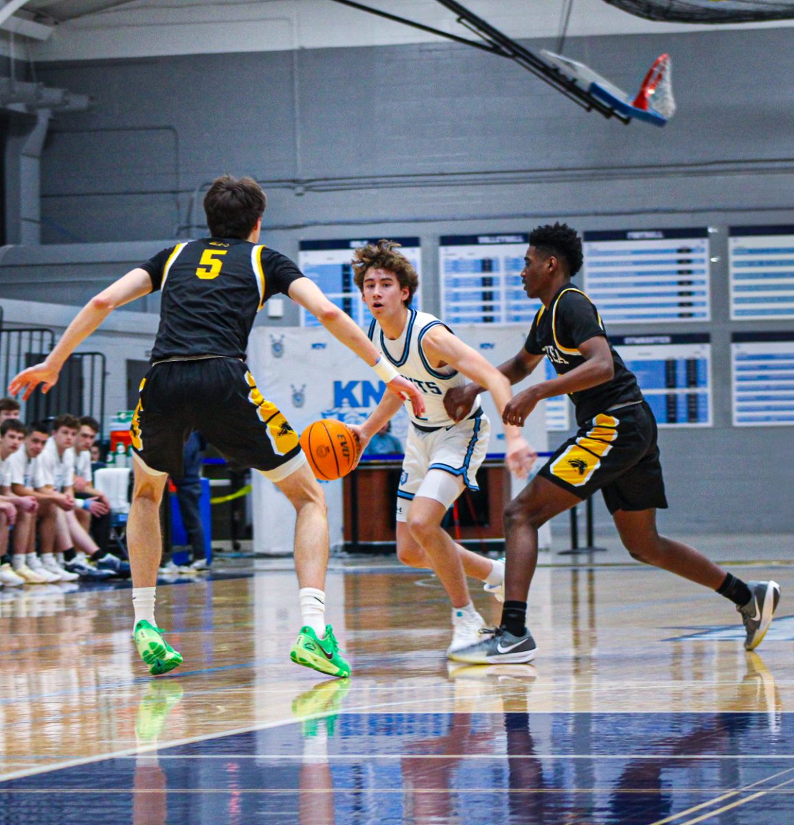 Junior Colin Tucker spots a gap between Metea Valley senior Jake Nosek (left) and junior Tre Watkins (right) as the two try to guard him during Prospect’s senior night matchup against Metea Valley.