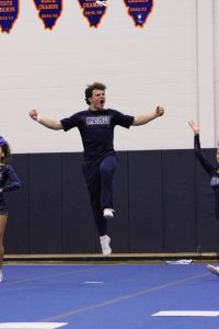 Junior Andrew Hiselman jumping up and down hyping up the crowd before the routine starts.