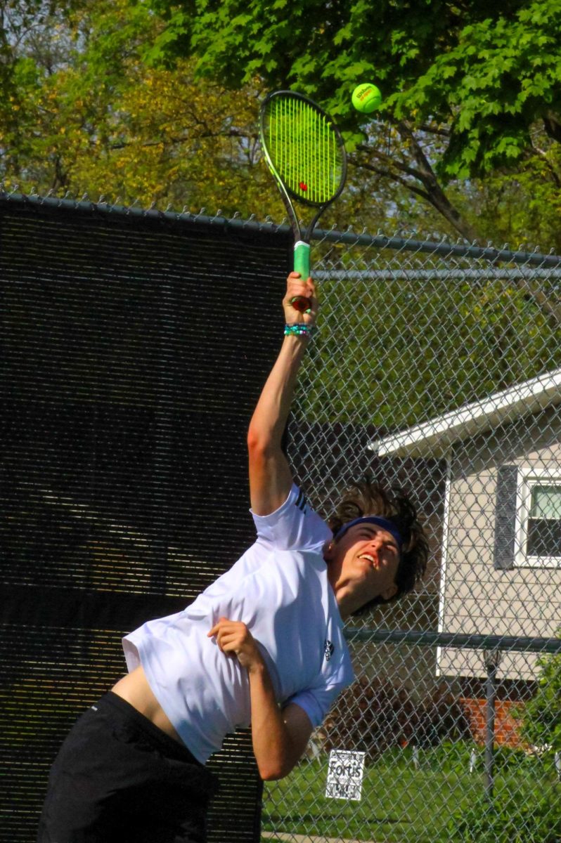 Junior David Colias serves the ball to his teammate during practice.