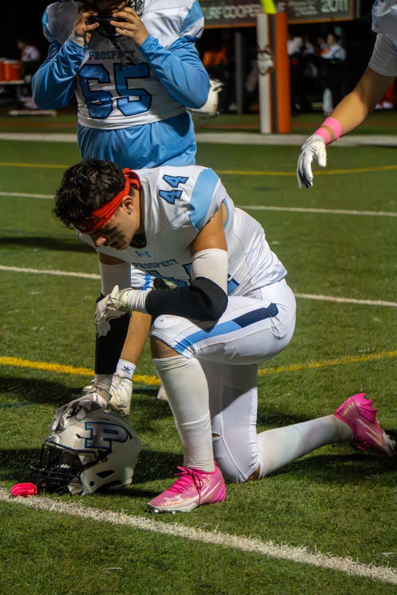Senior Connor Curran prays before the game